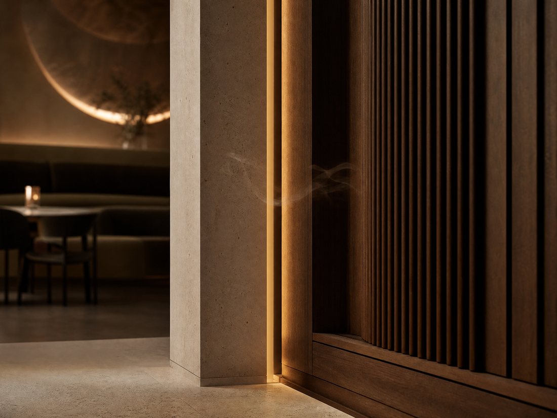 Warm light and a wisp of scent emerging from behind concealed timber joinery in a dark interior